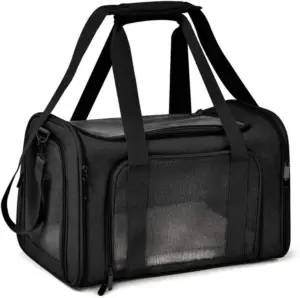 A black pet carrier bag with mesh ventilation windows, multiple black straps, and zippers, designed for pet transportation, set against a white background.